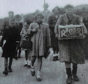 Family group with boy carrying a box with 'Rinso' on it