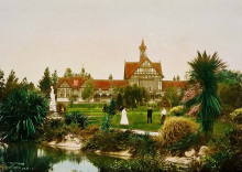 Ornate building with people walking around beautiful grounds with native trees and ponds.