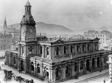 Original University of Otago building with horse-drawn carts in front.