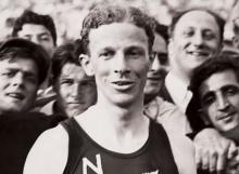 Jack Lovelock wearing a New Zealand running singlet in a crowd