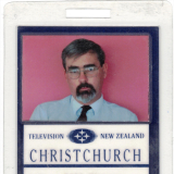 Identification card featuring text and picture of a bearded man with glasses in shirt and tie