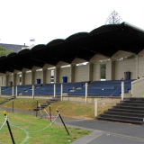 Sports grandstand at the side of roped-off grass sports field