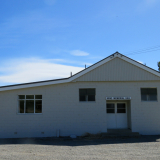 Wooden hall with gravel carpark