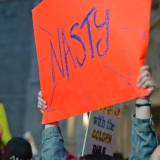 Women holding up 'Nasty' sign