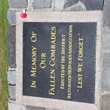 Black plaque set into ground with gold writing