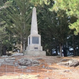 Memorial obelisk set among pine trees