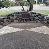 Stone wall with plaque inlaid in the centre.