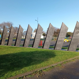 Sculpture of nine slanted columns representing soldiers and their horses marching