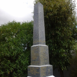 Photograph of an obelisk shaped marble memorial with names listed on each side