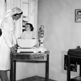 Plunket nurse weighing a baby