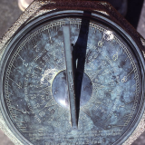 Bronze sundial featuring inscriptions of words, numbers, and arrows