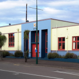 Profile view of cream and blue coloured building. Photographed from across a road.