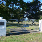 Cast iron gates inlaid with the word 'Mangateparu' between two white pillars