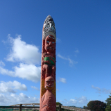 Red carved Māori pouwhenua (land post)