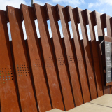 Line of connected bronze panels with black plaque with text at the end of the row