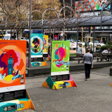 An urban park decorated with five large colourful posters.