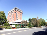 Multi-story library building with bus stop and road in front