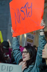 Women holding up 'Nasty' sign