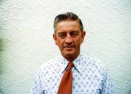Elderly man in white printed shirt and red tie