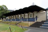 Sports grandstand at the side of roped-off grass sports field