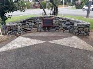 Stone wall with plaque inlaid in the centre.