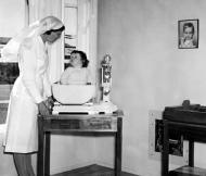 Plunket nurse weighing a baby