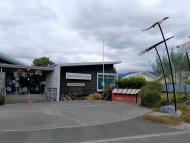 Exterior of modern building with sculptures, and flagpole in the foreground.