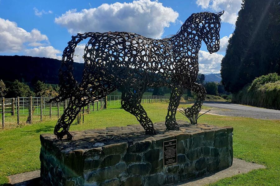 Bronze metal in the shape of horse on plinth made of rocks