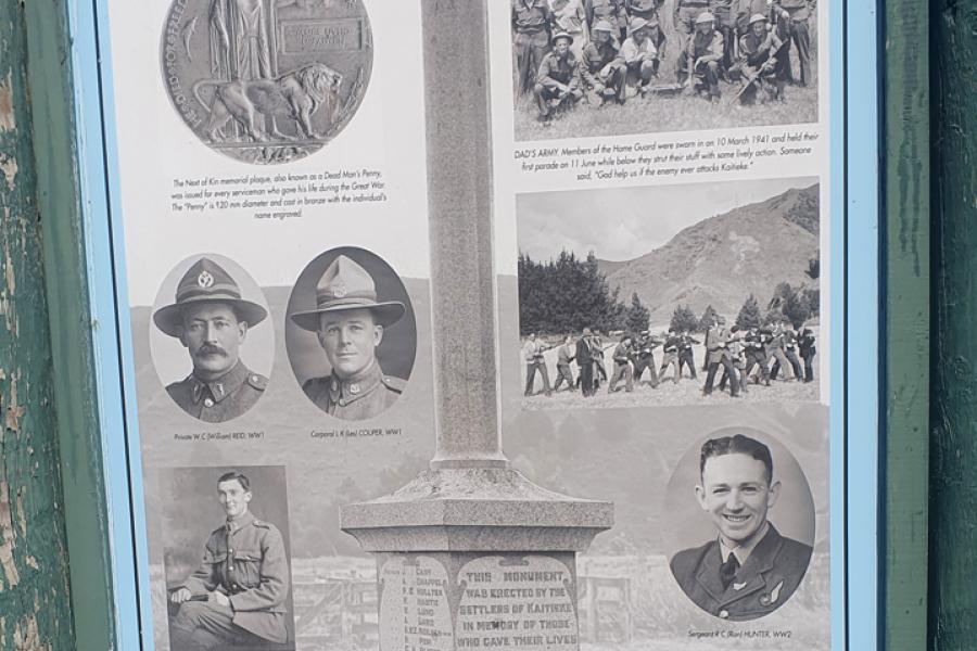 Sign featuring historic photographs and text in green wooden frame