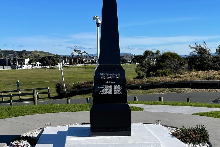 Black granite obelisk set into concrete inlaid with the words Lest we Forget