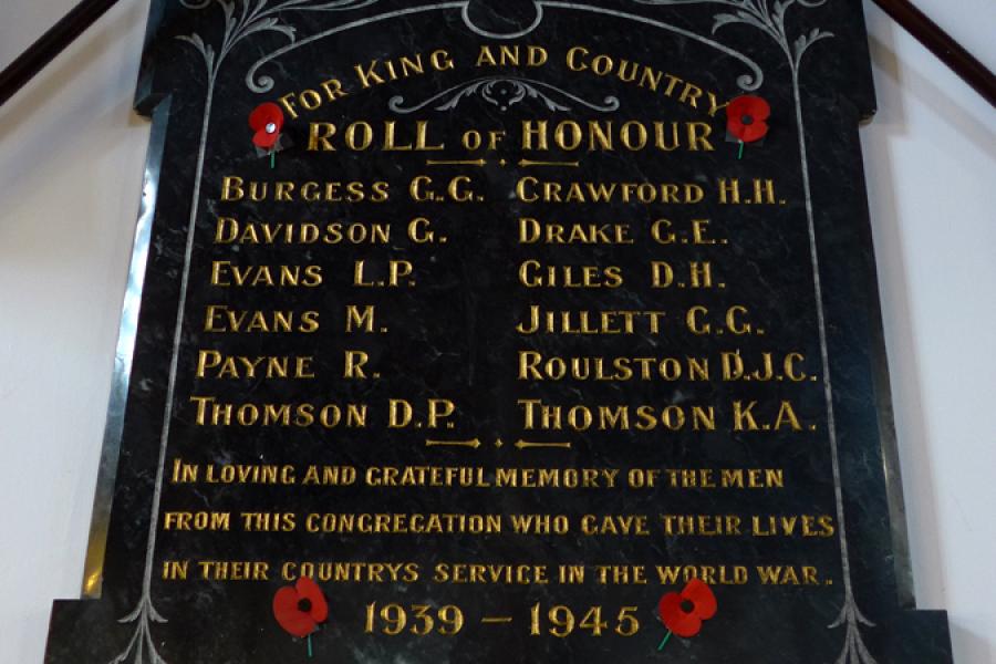 Wooden board on wall with list of names in gold lettering