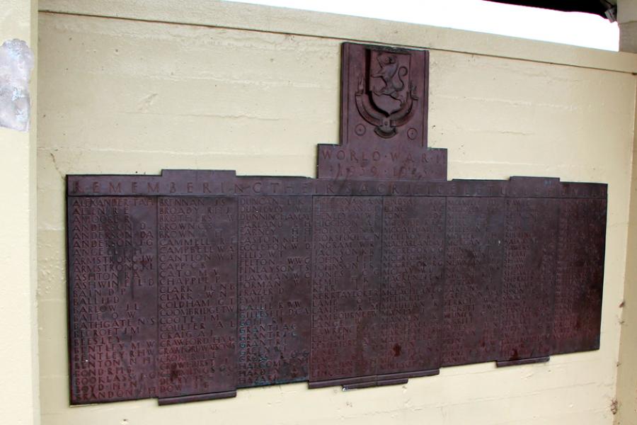 Brass plaque with list of names fixed to wall