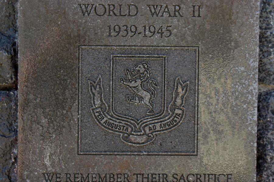 Stone plaque inscribed with writing attached to brick wall