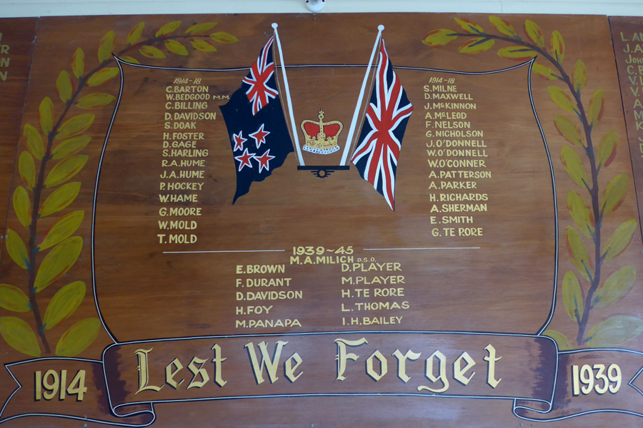 Detail of wooden plaque with two crossed flags and list of names in gold lettering