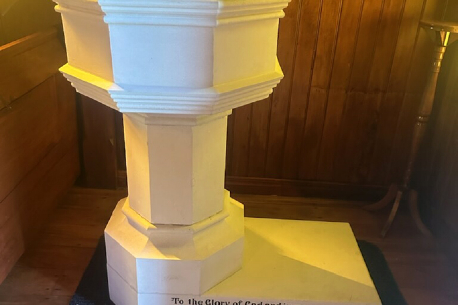 White baptismal font inside church