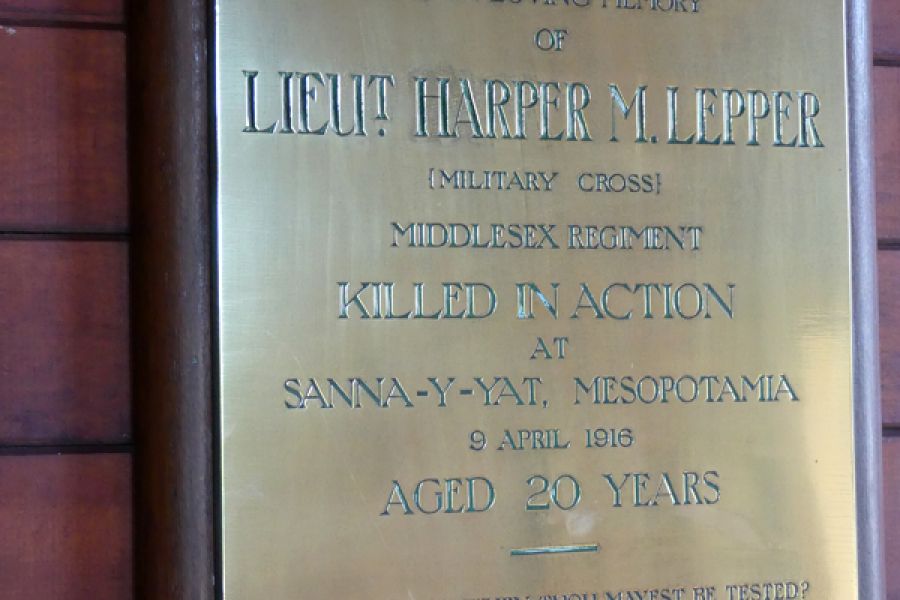 Brass memorial plaque on wall inside church