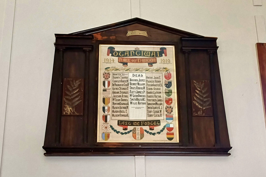 Scroll with list of names in centre of wooden board