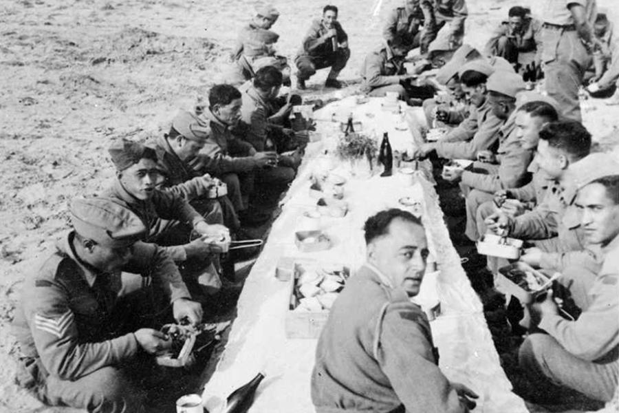 Members of 28th (Māori) Battalion eating Christmas dinner in the desert, Nofilia, Libya, 1942.