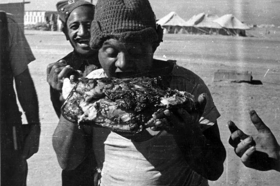 Enjoying a leg of pork from a Xmas hangi in Maadi, Egypt, 1943.
