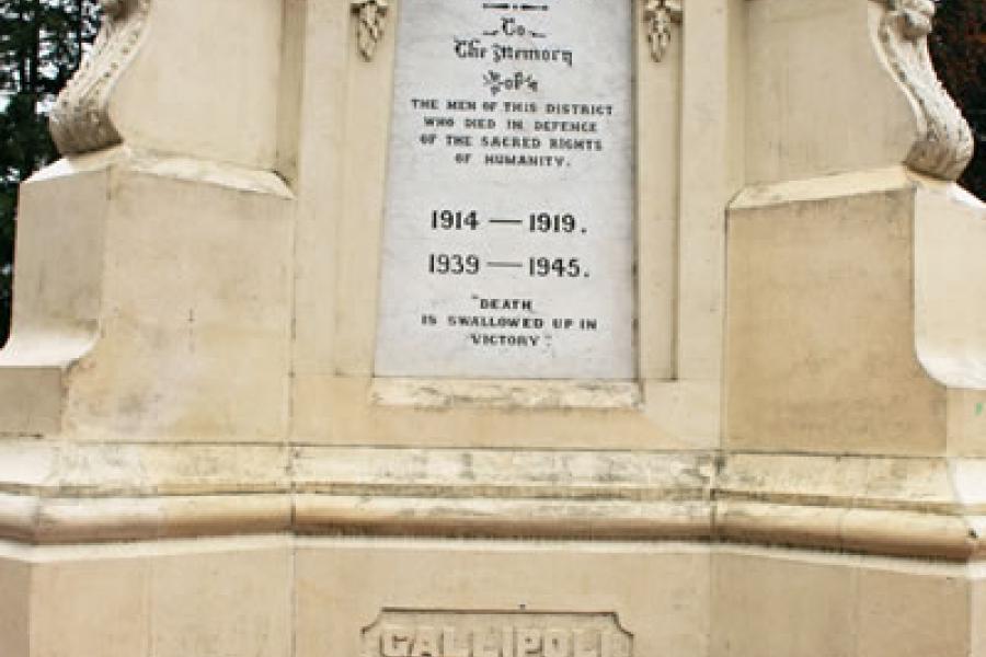 Stone column featuring marbel memorial panel, ornamental urns and lampstands