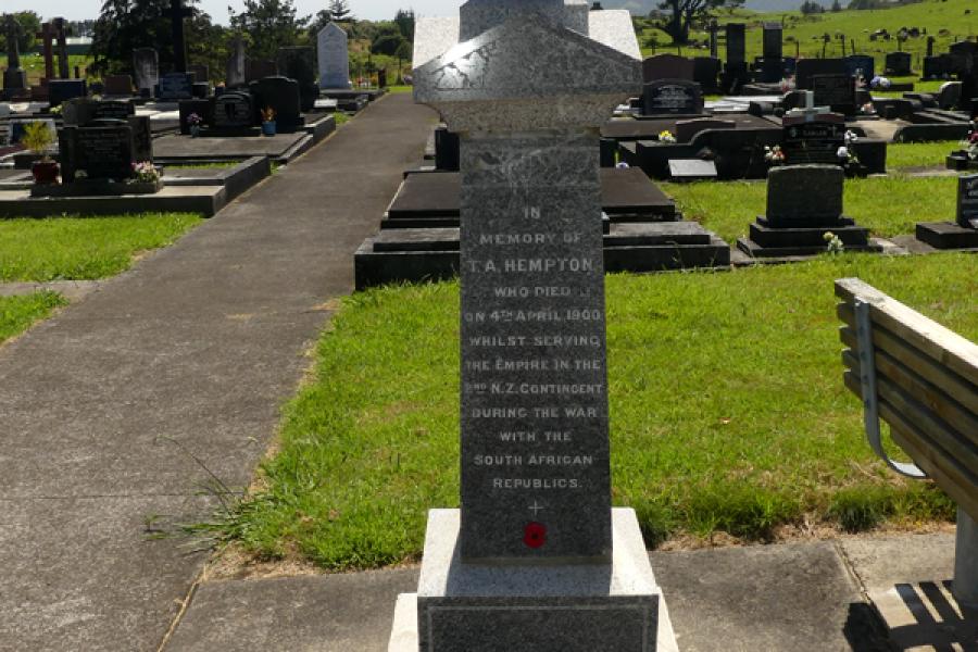 Stone obelisk with cemetery graves and headstones in background