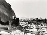 Debris from aircraft strewn over snow with flags planted amongst them