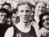 Jack Lovelock wearing a New Zealand running singlet in a crowd