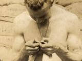 New Zealand soldier checking his shirt for lice, May 1917