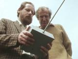 Two men holding a remote control device