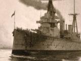 HMS New Zealand on the water with smoke pouring out of chimney.