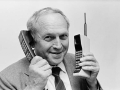 Smiling man holding two large mobile phones