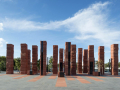A group of red coloured pillars arranged on a concrete foundation