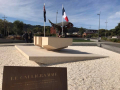 Stone blocks sitting on limestone gravel with New Zealand and French flags in the background