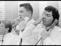 Three men in shirts and ties on telephone looking stressed